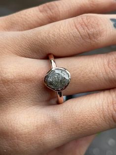 a woman's hand with a ring on it and a stone in the middle