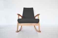 a black rocking chair against a white wall