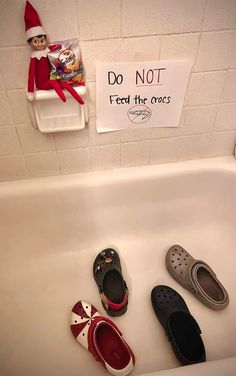 several pairs of shoes are lined up on the sink in front of a sign that says do not feed the croces