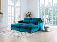 a living room with blue couches and white walls, hardwood floors and chandelier