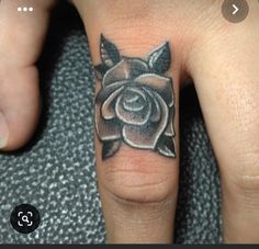 a person with a rose tattoo on their finger