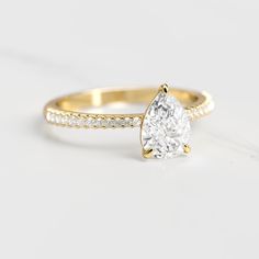 a rose gold engagement ring with a pear shaped diamond