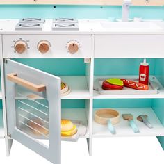 a toy stove with various cooking utensils on the shelves and in front of it