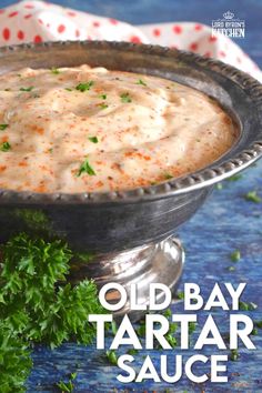 an old - bay tartar sauce in a silver bowl with parsley on the side