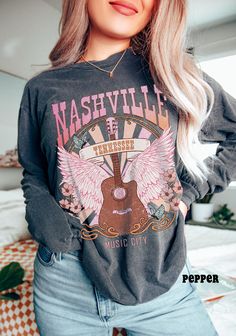 Nashville, Country Music Shirt, Comfort Colors® Long Sleeve Shirt, Boho Vintage Guitar Tee, Retro Country Western Music Lover Gifts SIZE UP for an OVERSIZED FIT (see size chart in listing photos). Our shop uses direct-to-garment printing to make our products. The design ink is sprayed on, then allowed to soak into the fibers of the garment. This process yields fine quality prints and a smooth finish on the garment. COMFORT COLORS UNISEX T SHIRT Made with 100% ring-spun cotton, these personalized long-sleeve shirts come packed with softness and style. Each tee features garment-dyed fabric and comes with a relaxed fit for total comfort in any casual setting. Add your designs and create an instant wardrobe favorite.  .: 100% ring-spun cotton .: Medium fabric (6.1 oz/yd² (206.8 g/m .: Classic Nashville Country Music, Cotton Band Merch T-shirt For Country Concerts, Country Music Tee Shirts, Music Lover Gifts, Music-themed Cotton T-shirt For Concerts, Retro Cotton T-shirt For Country Concerts, Nashville Country, 90s Country Music Tshirts, Music Shirts