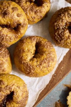 several doughnuts sitting on top of a piece of wax paper