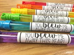 four markers with words on them sitting next to each other in front of a wooden table