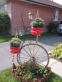 an old wheel with flower pots on it