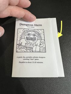 a hand holding a card with an image of a demon on it