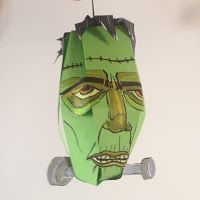 a green paper mask hanging from a hook