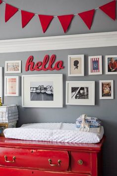 a baby's room with red dressers and pictures on the wall above it