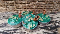 three tins filled with food sitting on top of a wooden table next to a wicker basket