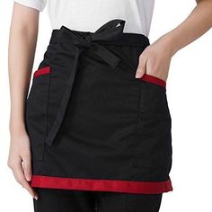 the woman is wearing an apron with a bow on it's belt and has her hands in her pockets