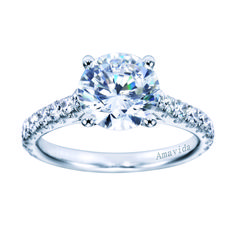 a white gold engagement ring with diamonds on the band and an oval cut diamond in the center