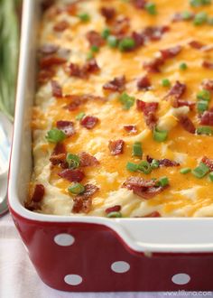 a casserole dish with bacon, cheese and green onions