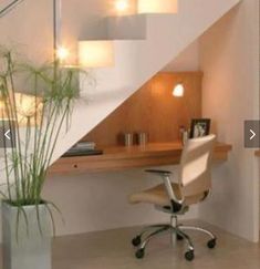 an office area with a desk, chair and plant in the corner next to stairs