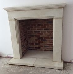 an empty fireplace in the corner of a room with no one around it or on the floor