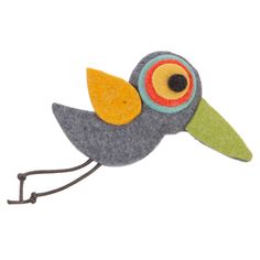 a felt bird sitting on top of a metal hook with an orange beak and yellow eyes