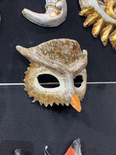 an assortment of masks on display in a store window, including one with a bird's head