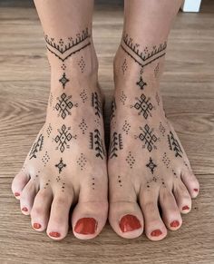 a woman's feet with tattoos on them