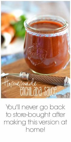 a jar filled with sauce sitting on top of a wooden cutting board