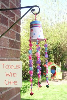 a child's wind chime hanging from a brick wall