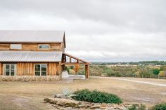 a large wooden house sitting on top of a dry grass field