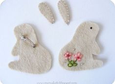 two felt rabbits with flowers on them and one has a flower in its earring