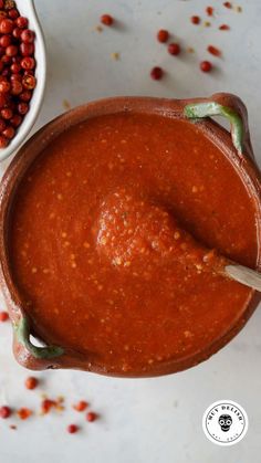 a bowl filled with red beans next to a white bowl