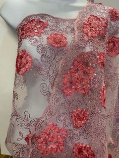 a dress with pink flowers on it sitting on a mannequin