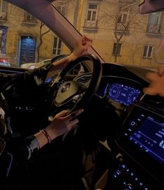 a woman driving a car at night with her hands on the steering wheel