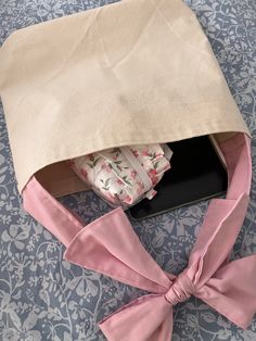 a pink bow is tied to the side of a bag