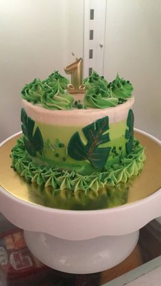 a cake with green frosting and leaves on it