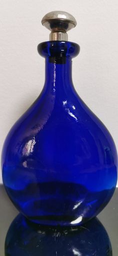 a blue glass vase sitting on top of a table