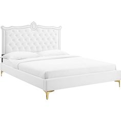 a white bed with gold legs and headboard