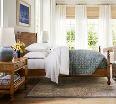 a bed sitting in a bedroom next to two chairs and a table with flowers on it