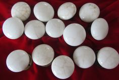 several white marble knobs on a red cloth