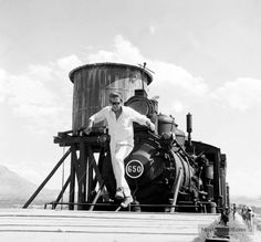 black and white photograph of a man leaning on a train