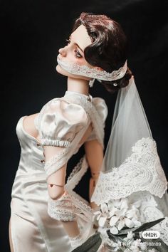 a woman in a wedding dress and veil with her hand on her face, posing for the camera