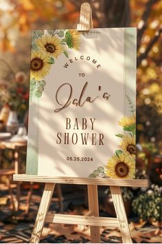 a welcome sign for a baby shower with sunflowers and leaves on the back