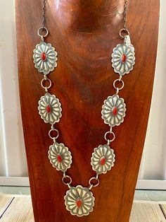 Beautiful seven silver and coral Concho long 30" inch length sterling silver Native American made statement necklace. The piece is stamped sterling and signed "DM" on the back of the necklace by artist DM Begay. Size: 30" Inches in length Stone: Coral Signed: YES "DM" Hallmark/ Artist: DM Begay Concho Necklace, Deodorant Stains, Makeup Stain, Jewelry Care Instructions, Coral Jewelry, Western Jewelry, Native American Jewelry, American Made, Jewelry Care