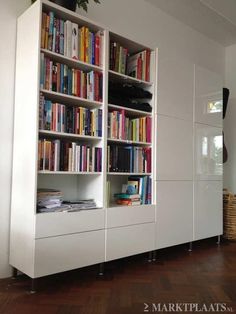 a white bookcase with lots of books on it