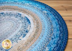 a blue and white round rug on top of a wooden floor next to a clock