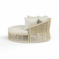 a wicker chair with pillows on top of it and white cushions around the seat