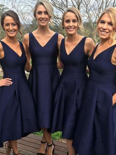 four beautiful women in blue dresses posing for the camera