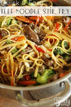 a skillet filled with beef noodles and broccoli, carrots and peppers