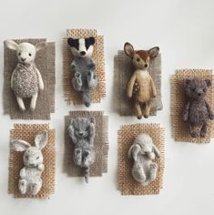 six stuffed animals are placed on burlap and pinned to the wall, each with an animal's own head