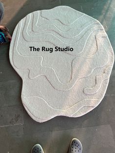 the rug studio logo is displayed in front of someone's feet