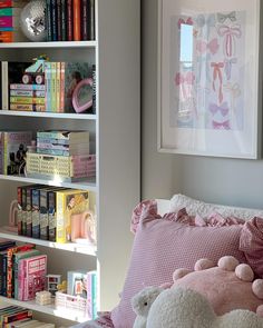 a bedroom with bookshelves and stuffed animals on the bed in front of it