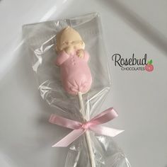 a pink and white lollipop with a baby doll on it